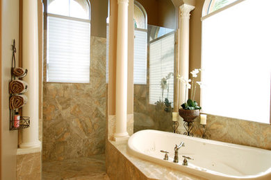 オーランドにある高級な広い地中海スタイルのおしゃれなマスターバスルーム (大理石の洗面台、大型浴槽、ベージュのタイル、ベージュの壁、大理石の床) の写真