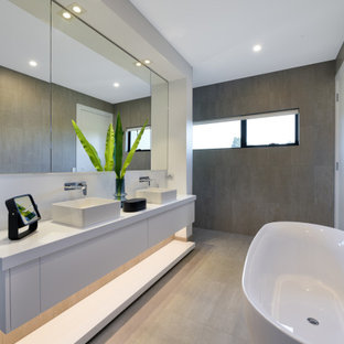 Design ideas for a large contemporary master bathroom in Melbourne with flat-panel cabinets, white cabinets, a freestanding tub, gray tile, white walls, a vessel sink, beige floor, white benchtops, a double vanity and a floating vanity.