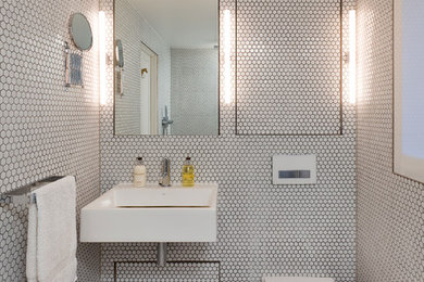 Inspiration för ett funkis badrum, med vit kakel, mosaik, en toalettstol med hel cisternkåpa, ett väggmonterat handfat, vita väggar och mosaikgolv