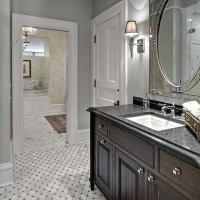 Bathroom - traditional bathroom idea in Minneapolis with raised-panel cabinets, dark wood cabinets, gray walls, an undermount sink and granite countertops