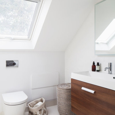 Small danish master white tile and ceramic tile single-sink, ceramic tile and beige floor bathroom photo in Sussex with flat-panel cabinets, dark wood cabinets, an integrated sink, solid surface countertops, white countertops, a floating vanity and a one-piece toilet