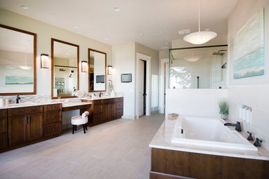 Large traditional ensuite bathroom in Boise with raised-panel cabinets, dark wood cabinets, a corner bath, a corner shower, grey tiles, beige walls, ceramic flooring and quartz worktops.