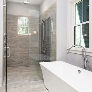 Foto på ett stort vintage en-suite badrum, med luckor med infälld panel, vita skåp, ett fristående badkar, en kantlös dusch, grå kakel, porslinskakel, grå väggar, klinkergolv i porslin, ett undermonterad handfat, bänkskiva i kvartsit, grått golv och dusch med gångjärnsdörr