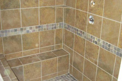 Example of a multicolored tile and mosaic tile corner shower design in Austin