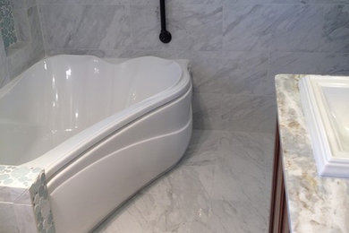 Exempel på ett mellanstort modernt en-suite badrum, med luckor med upphöjd panel, skåp i mellenmörkt trä, ett fristående badkar, en hörndusch, stenhäll, vita väggar, marmorgolv, ett nedsänkt handfat och marmorbänkskiva