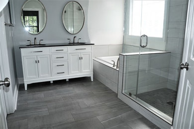Large transitional master gray tile and porcelain tile porcelain tile bathroom photo in Charlotte with recessed-panel cabinets, white cabinets, a two-piece toilet, gray walls, an undermount sink and marble countertops