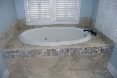 Example of a porcelain tile porcelain tile drop-in bathtub design in Tampa with blue walls