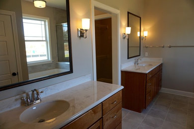 Foto de cuarto de baño principal clásico de tamaño medio con armarios con paneles empotrados, puertas de armario de madera oscura, paredes grises, suelo de baldosas de porcelana, lavabo bajoencimera y suelo gris