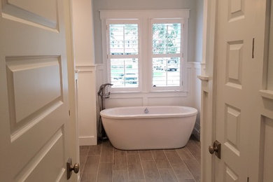 Modelo de cuarto de baño clásico de tamaño medio con bañera exenta, suelo de baldosas de porcelana y suelo marrón