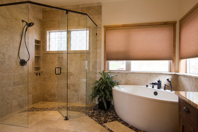 Design ideas for a large traditional ensuite bathroom in Albuquerque with a vessel sink, recessed-panel cabinets, granite worktops, a freestanding bath, a corner shower, a two-piece toilet, beige tiles, stone tiles, beige walls and travertine flooring.
