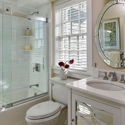 Tub/shower combo - traditional white tile and subway tile mosaic tile floor tub/shower combo idea in Philadelphia with an undermount sink, white cabinets, a two-piece toilet, beige walls, furniture-like cabinets and marble countertops