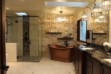 Inspiration for a large timeless master ceramic tile and beige tile ceramic tile and beige floor bathroom remodel in Seattle with recessed-panel cabinets, a one-piece toilet, an undermount sink, a hinged shower door, dark wood cabinets, beige walls, granite countertops and black countertops