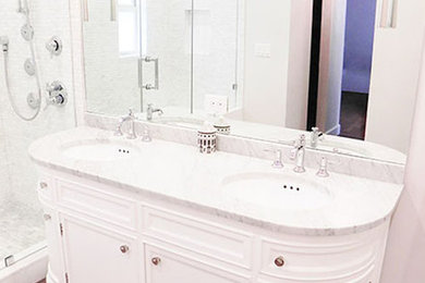 Inredning av ett modernt mellanstort badrum med dusch, med luckor med infälld panel, vita skåp, en dusch i en alkov, grå kakel, vit kakel, stenkakel, vita väggar, mellanmörkt trägolv, ett undermonterad handfat, marmorbänkskiva, brunt golv och dusch med gångjärnsdörr
