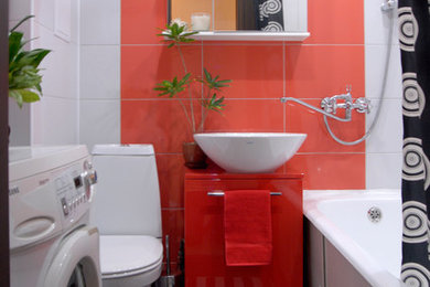 エカテリンブルクにある小さなコンテンポラリースタイルのおしゃれな浴室 (フラットパネル扉のキャビネット、赤いキャビネット、シャワー付き浴槽	、一体型トイレ	、赤いタイル、セラミックタイル、白い壁、セラミックタイルの床、オーバーカウンターシンク、木製洗面台) の写真
