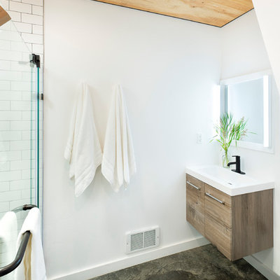 Inspiration for a mid-sized rustic 3/4 white tile and subway tile concrete floor and gray floor walk-in shower remodel in Other with open cabinets, a two-piece toilet, white walls, an integrated sink, solid surface countertops, a hinged shower door and white countertops