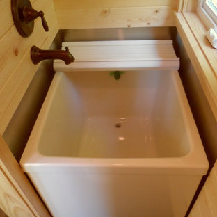 Aménagement d'une petit salle d'eau asiatique avec un bain japonais et un sol en bois foncé.