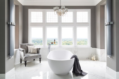 Inspiration för klassiska en-suite badrum, med ett fristående badkar, vit kakel, grå väggar och vitt golv