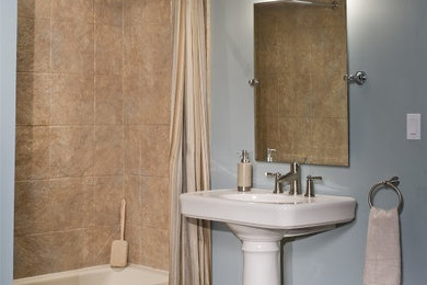 Imagen de cuarto de baño principal de tamaño medio con lavabo con pedestal, bañera empotrada, combinación de ducha y bañera, baldosas y/o azulejos beige y paredes azules