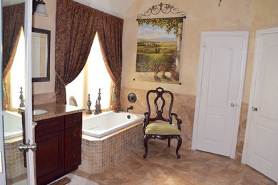 Mid-sized elegant master beige tile bathroom photo in Austin with an undermount sink, raised-panel cabinets, dark wood cabinets, granite countertops, a one-piece toilet and beige walls