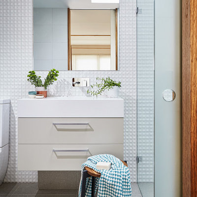 Walk-in shower - small contemporary 3/4 porcelain tile walk-in shower idea in Melbourne with beige cabinets, white walls, solid surface countertops, flat-panel cabinets and an integrated sink