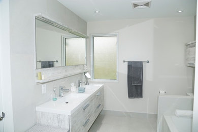 Example of a mid-sized minimalist 3/4 ceramic tile and white floor corner bathtub design in Toronto with flat-panel cabinets, white cabinets, white walls, an integrated sink and quartz countertops