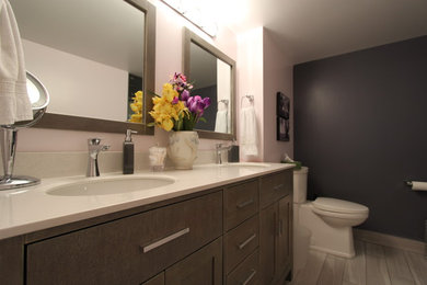 Imagen de cuarto de baño principal tradicional de tamaño medio con armarios estilo shaker, ducha empotrada, sanitario de una pieza, paredes rosas, lavabo bajoencimera, encimera de cuarcita, puertas de armario grises y suelo de madera clara