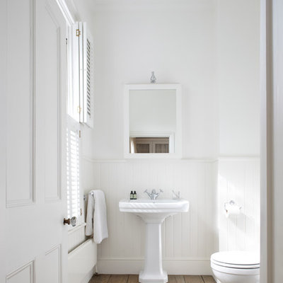 Inspiration for a victorian medium tone wood floor and brown floor bathroom remodel in Sussex with a pedestal sink and white walls