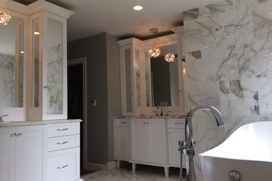 Mid-sized elegant master multicolored tile and stone tile marble floor freestanding bathtub photo in Louisville with flat-panel cabinets, white cabinets, multicolored walls, an undermount sink and marble countertops