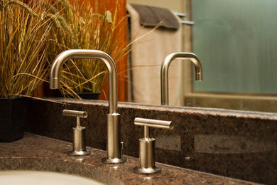 This is an example of a large classic ensuite bathroom in Milwaukee with raised-panel cabinets, dark wood cabinets, a corner bath, an alcove shower, a one-piece toilet, beige tiles, stone slabs, brown walls, travertine flooring, a submerged sink and granite worktops.