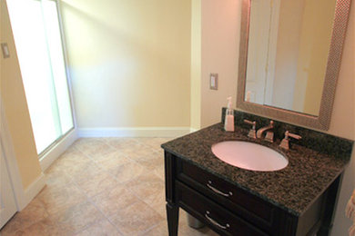 フィラデルフィアにあるトラディショナルスタイルのおしゃれな浴室 (オーバーカウンターシンク、家具調キャビネット、黒いキャビネット、ベージュの壁) の写真