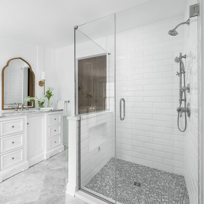 Walk-in shower - mid-sized traditional master white tile and subway tile marble floor and white floor walk-in shower idea in Chicago with recessed-panel cabinets, white cabinets, a two-piece toilet, white walls, an undermount sink, marble countertops, a hinged shower door and white countertops