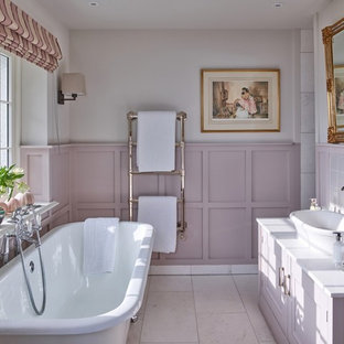 Inspiration for a medium sized traditional ensuite bathroom in Other with raised-panel cabinets, purple cabinets, a freestanding bath, pink tiles, beige walls, a vessel sink, beige floors and white worktops.