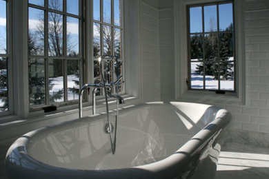 Imagen de cuarto de baño clásico con bañera exenta, baldosas y/o azulejos blancos y suelo de mármol