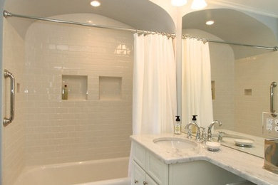 ミルウォーキーにある中くらいなトラディショナルスタイルのおしゃれなバスルーム (浴槽なし) (レイズドパネル扉のキャビネット、白いキャビネット、アルコーブ型浴槽、分離型トイレ、白いタイル、セラミックタイル、青い壁、磁器タイルの床、アンダーカウンター洗面器、大理石の洗面台、マルチカラーの床) の写真
