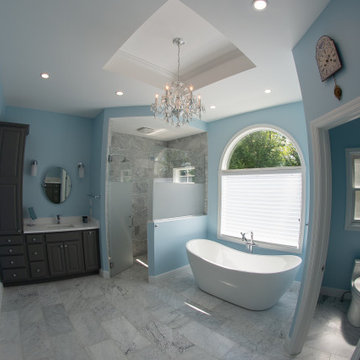 Traditional master bath utilizing frosted and clear glass to allow for needed pr