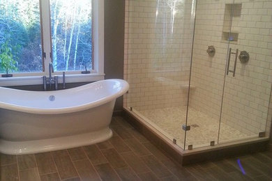 Foto på ett mellanstort vintage en-suite badrum, med vita skåp, ett fristående badkar, en hörndusch, en toalettstol med separat cisternkåpa, gröna väggar, vinylgolv, ett undermonterad handfat, luckor med profilerade fronter, bänkskiva i kalksten och brunt golv