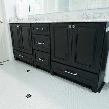 Traditional master bathroom with dark wood vanity & penny tile floor