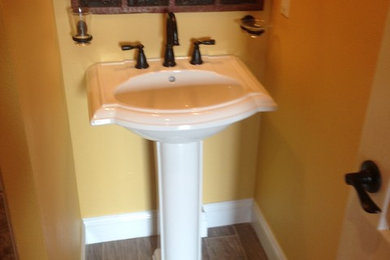 マイアミにあるお手頃価格の小さなトラディショナルスタイルのおしゃれなバスルーム (浴槽なし) (ペデスタルシンク、茶色いタイル、磁器タイル、黄色い壁、磁器タイルの床) の写真