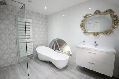 Exemple d'une salle de bain tendance de taille moyenne avec un placard à porte plane, une baignoire indépendante, une douche ouverte, un bidet, un carrelage gris, des carreaux de céramique, un mur blanc et un lavabo encastré.