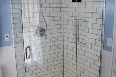 Elegant white tile and ceramic tile mosaic tile floor corner shower photo in Portland with blue walls
