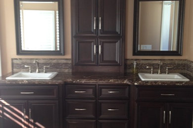 Inspiration for a timeless master bathroom remodel in Los Angeles with recessed-panel cabinets and dark wood cabinets