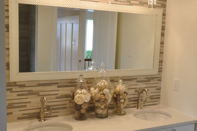 Foto de cuarto de baño principal tradicional con encimera de acrílico, armarios con paneles empotrados y puertas de armario blancas
