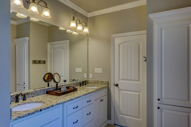 Immagine di una stanza da bagno padronale tradizionale di medie dimensioni con ante bianche, pareti beige, lavabo integrato e top in granito