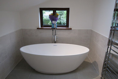 Contemporary family bathroom in Hampshire with a freestanding bath, a shower/bath combination, grey tiles, ceramic tiles, ceramic flooring and grey floors.