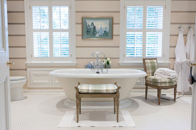 Imagen de cuarto de baño principal contemporáneo de tamaño medio con bañera exenta, combinación de ducha y bañera, sanitario de dos piezas, paredes beige y suelo con mosaicos de baldosas