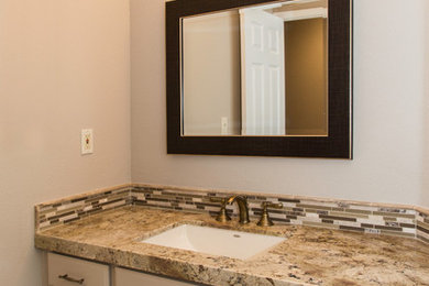 サクラメントにあるトランジショナルスタイルのおしゃれな浴室 (アンダーカウンター洗面器、ベージュのキャビネット、茶色いタイル、ベージュの壁) の写真