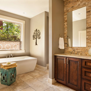 Ejemplo de cuarto de baño tradicional renovado con lavabo bajoencimera, armarios estilo shaker, puertas de armario de madera en tonos medios, bañera exenta y baldosas y/o azulejos de piedra