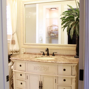 Inspiration for a mid-sized french country master white tile marble floor tub/shower combo remodel in New Orleans with furniture-like cabinets, beige cabinets, marble countertops, an integrated sink, a one-piece toilet and beige walls