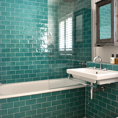 Transitional blue tile alcove bathtub photo in London with a wall-mount sink