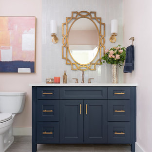 Inspiration for a mid-sized transitional 3/4 blue tile and glass tile gray floor bathroom remodel in Dallas with blue cabinets, pink walls, an undermount sink, quartzite countertops, white countertops, recessed-panel cabinets and a two-piece toilet